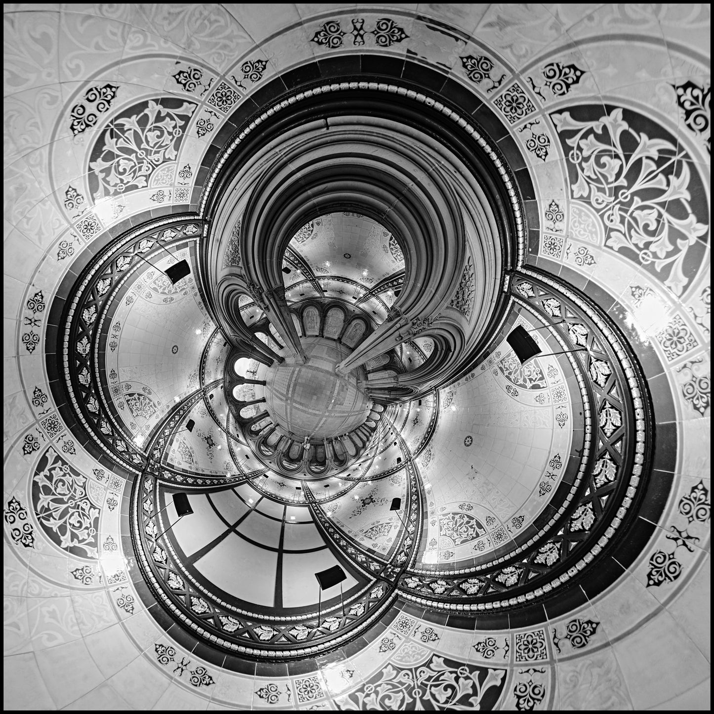Black and white spherical panoramic photograph of Bethesda Terrace's ornate Victorian architecture, transformed into a kaleidoscopic pattern with concentric arches and elaborate floral decorations spiraling toward a central point.