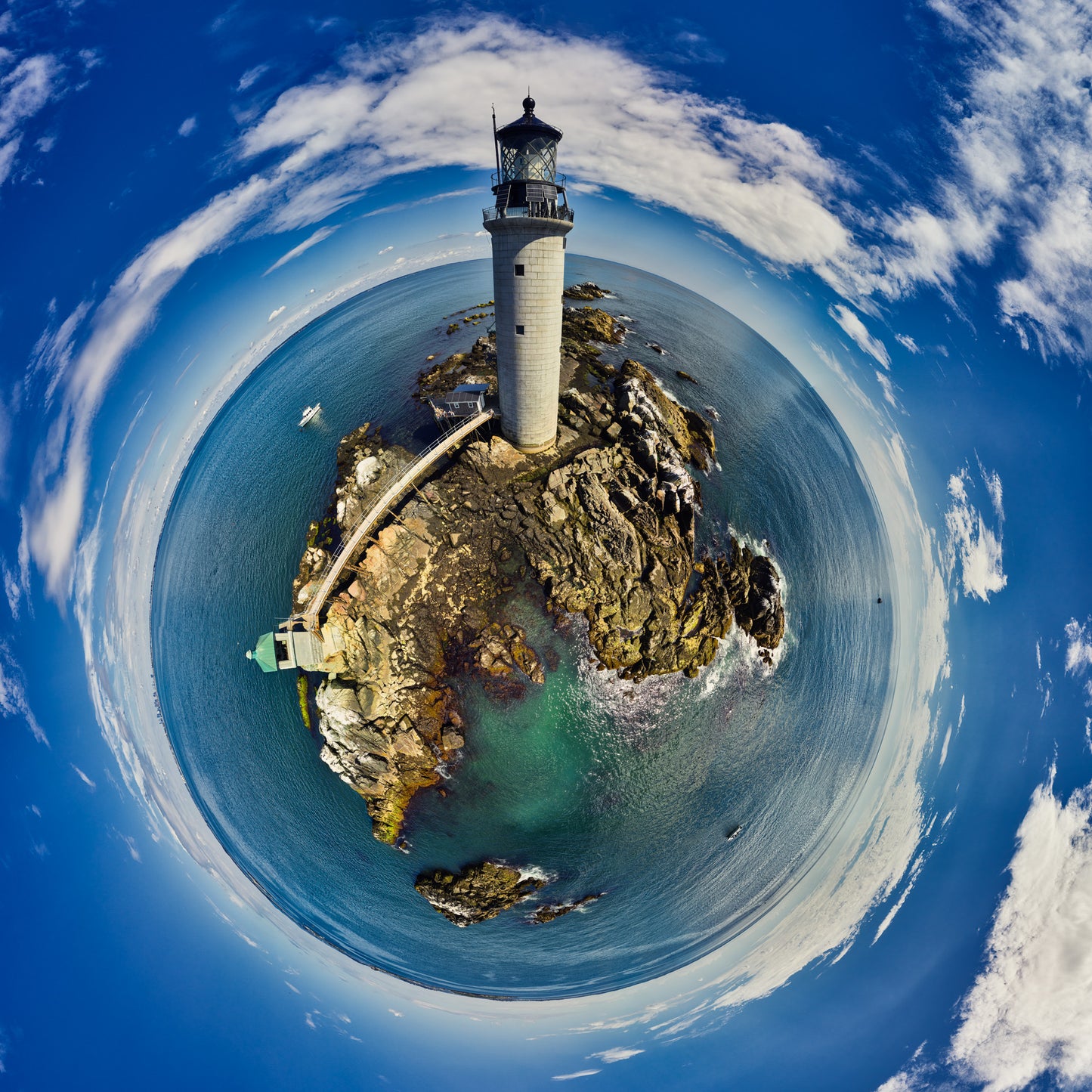 A 360-degree panoramic photograph of Graves Light Station rising from a rocky outcrop in Boston Harbor, featuring crystal blue waters, dramatic cloud formations, and a small boat nearby.