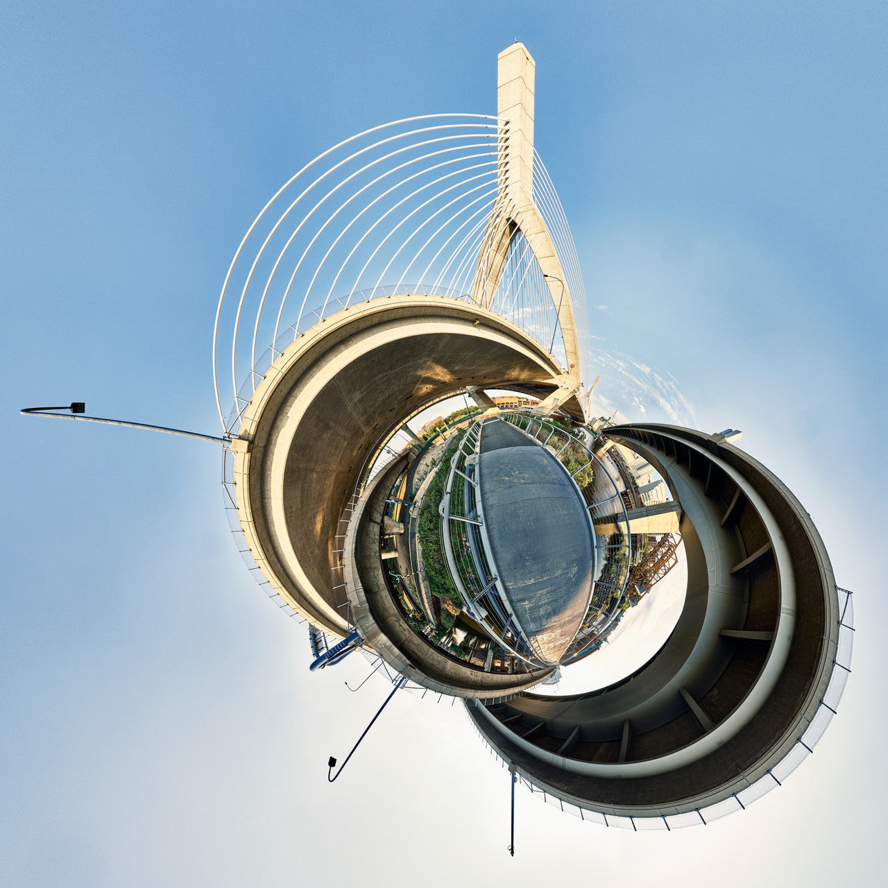 A 360-degree panoramic Spherescape of the Zakim Bridge in Boston, showcasing the bridge’s distinctive cable-stayed structure and towering pylons, captured in a circular format against a clear sky.