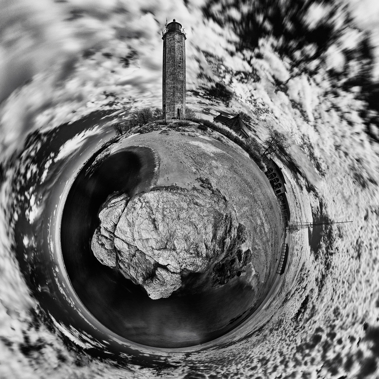 Black and white infrared spherescape of the New Haven Light in New Haven, CT, featuring a tall lighthouse, swirling clouds, and rugged landscape, emphasizing isolation and resilience.