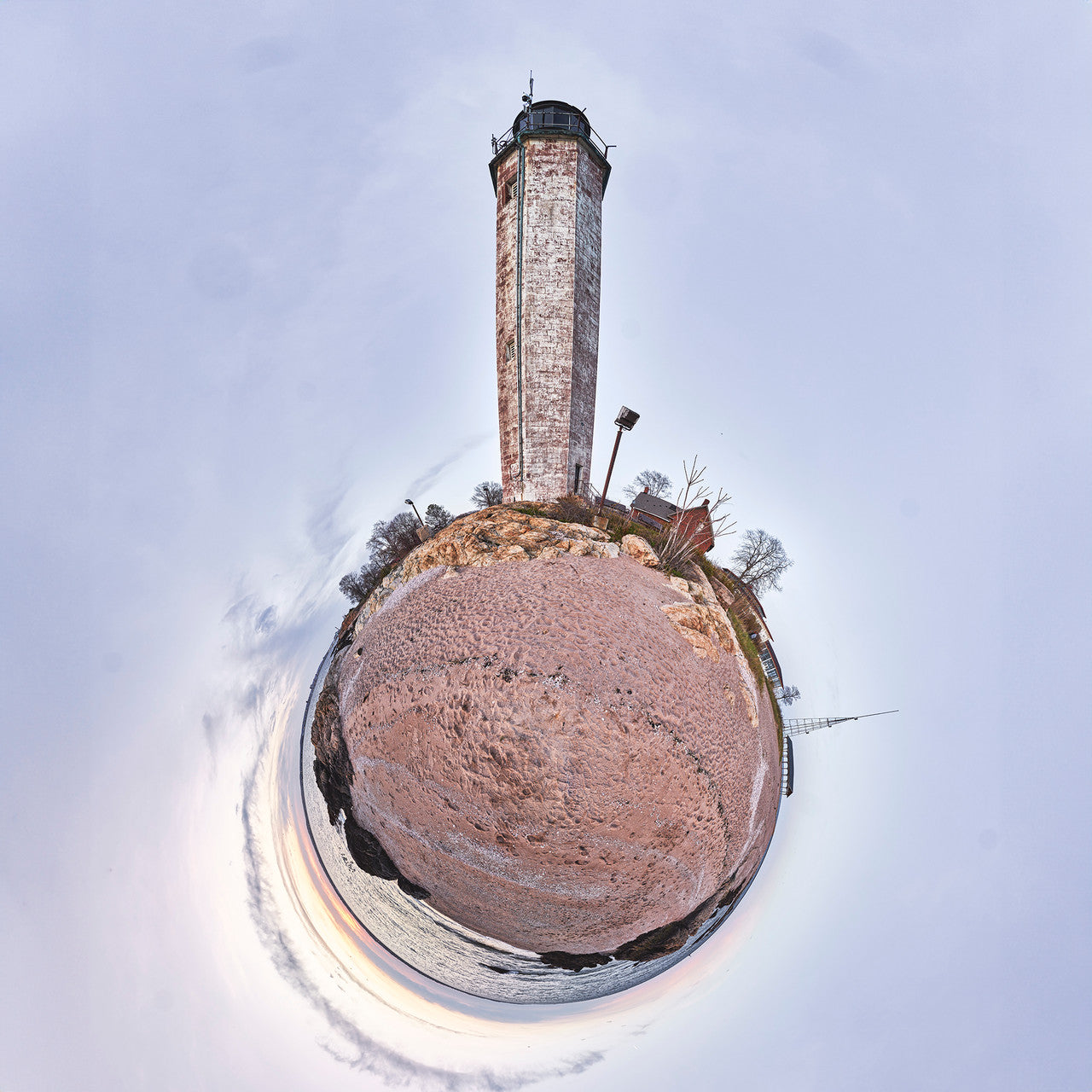 A 360-degree panoramic spherescape of New Haven Light in Connecticut, featuring the weathered brick lighthouse against a pastel sky. The landscape is a mix of sandy textures and rocky terrain.