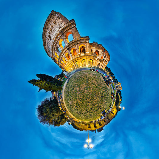 Spherical panoramic photograph of the Colosseum at twilight, illuminated in golden light against a deep blue sky, creating a planet-like effect with the ancient amphitheater crowning its own miniature world.